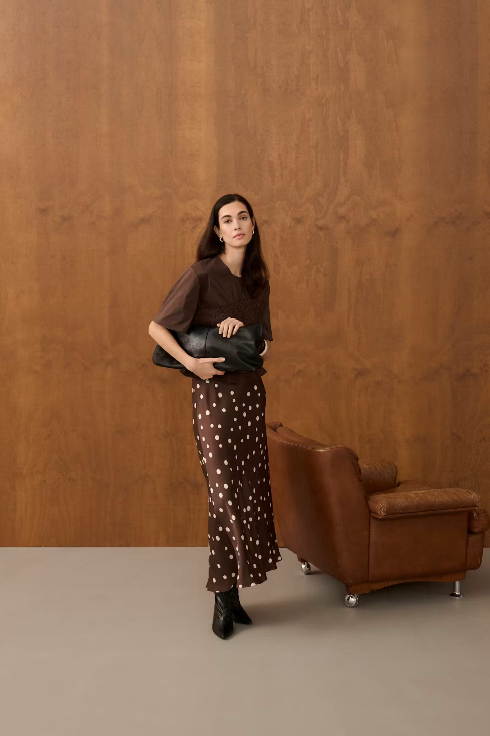 Full-length styled view of Culture Dotty Berna brown polka dot midi skirt