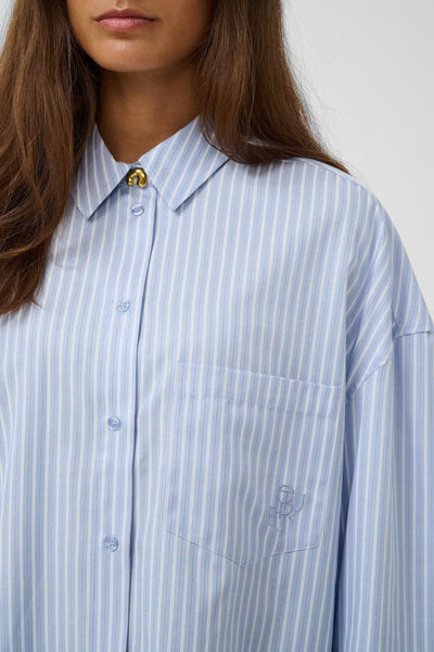 Close-up of Culture Manga blue and white striped shirt collar and chest pocket
