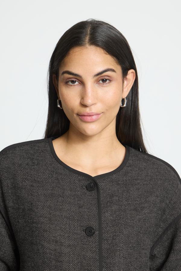 Close-up of ICHI Frava black herringbone jacket round neckline and buttons