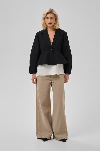 Full-length view of My Essential Wardrobe Evie black blazer with beige trousers
