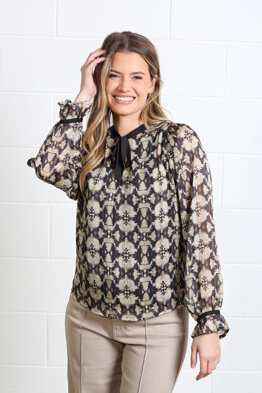 Rant & Rave Maria gold and black geometric print tie neck blouse front view